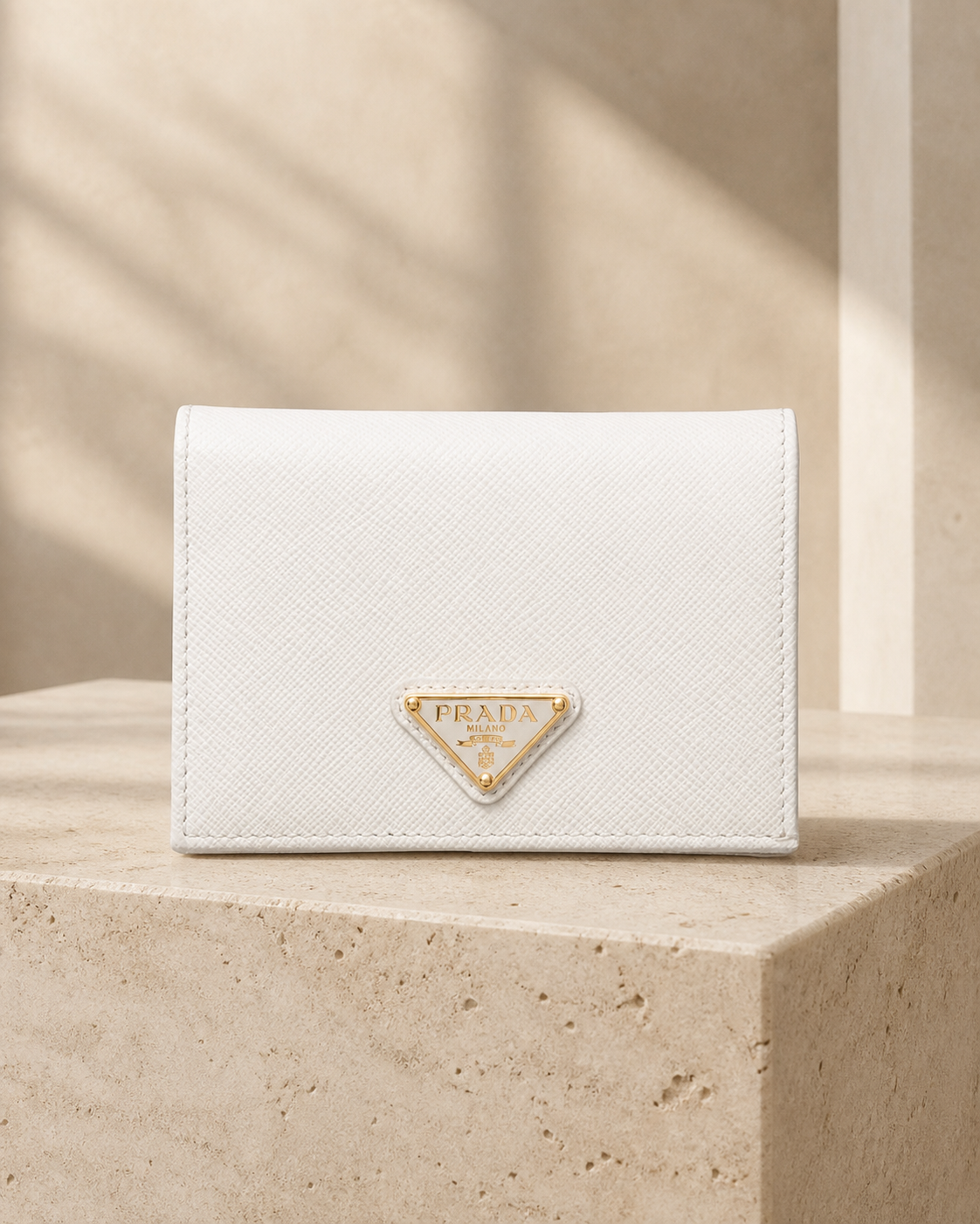 暖米色石材背景中的白色 Prada Saffiano 皮夾